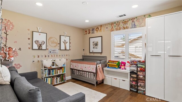 bedroom with wood finished floors and recessed lighting