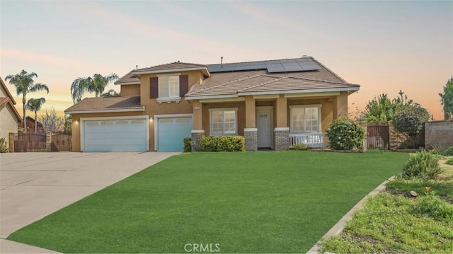 view of front facade with stucco siding, concrete driveway, solar panels, a porch, and a tiled roof