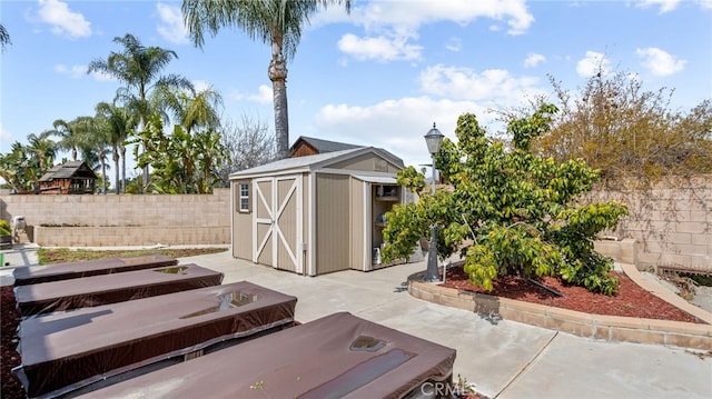view of patio featuring a shed, an outbuilding, and a fenced backyard
