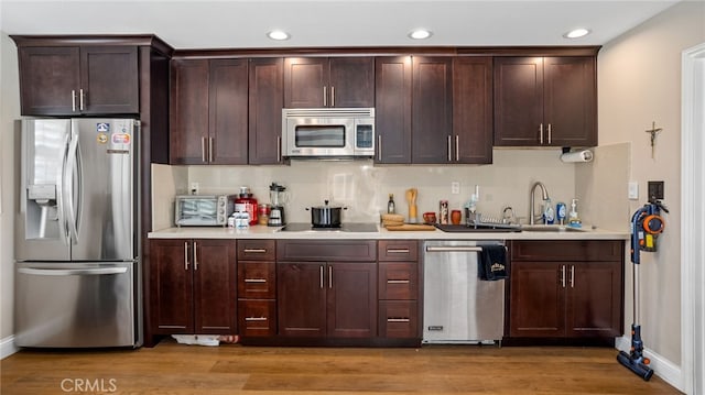 11815 Briarrose Ln, Chino, CA 91710 - kitchen with appliances with stainless steel finishes, light countertops, dark brown cabinets, recessed lighting, and light wood-type flooring