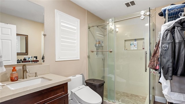 bathroom with a stall shower, vanity, and toilet