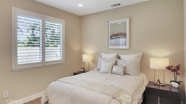 bedroom with baseboards, recessed lighting, and wood finished floors