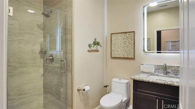 bathroom featuring a shower stall, toilet, and vanity