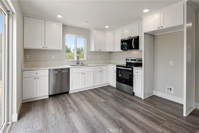 6018 William St, Riverside, CA 92504 - kitchen with stainless steel appliances, a sink, white cabinets, dark wood-style floors, and light countertops