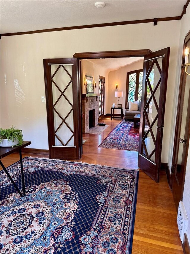 2415 N French St, Santa Ana, CA 92706 - foyer with wood finished floors, crown molding, baseboards, and a brick fireplace