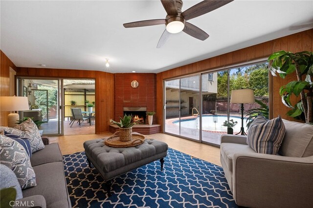 2415 N French St, Santa Ana, CA 92706 - living area featuring wood walls, a ceiling fan, and a fireplace
