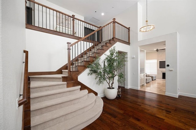 3044 Casmeg Way, El Cajon, CA 92019 - stairs featuring a towering ceiling, wood finished floors, a chandelier, recessed lighting, and a fireplace