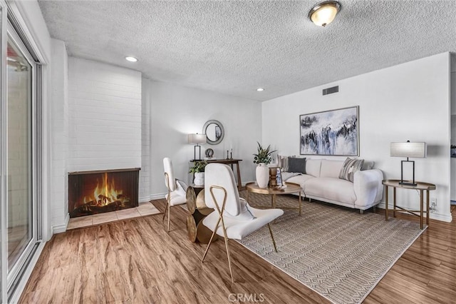 777 E Valley Blvd Unit 77, Alhambra, CA 91801 - living area with wood finished floors, a textured ceiling, a fireplace, recessed lighting, and baseboards