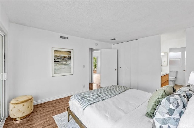 777 E Valley Blvd Unit 77, Alhambra, CA 91801 - bedroom featuring wood finished floors, multiple windows, a textured ceiling, connected bathroom, and baseboards
