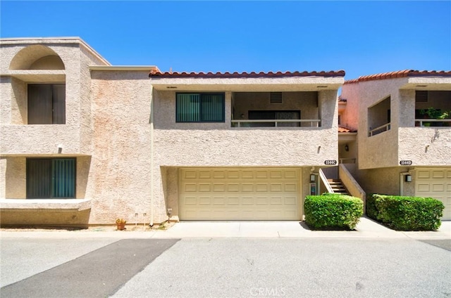1144 Walnut Grove Ave Unit C, Rosemead, CA 91770 - view of front facade featuring stucco siding, an attached garage, a tile roof, stairway, and a balcony