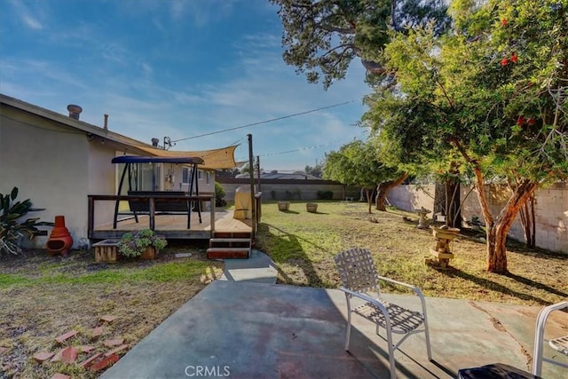 view of yard featuring a patio and a wooden deck