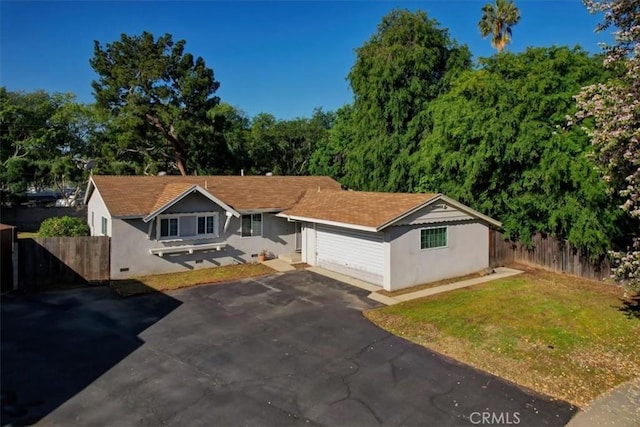 ranch-style home featuring stucco siding, driveway, and a garage