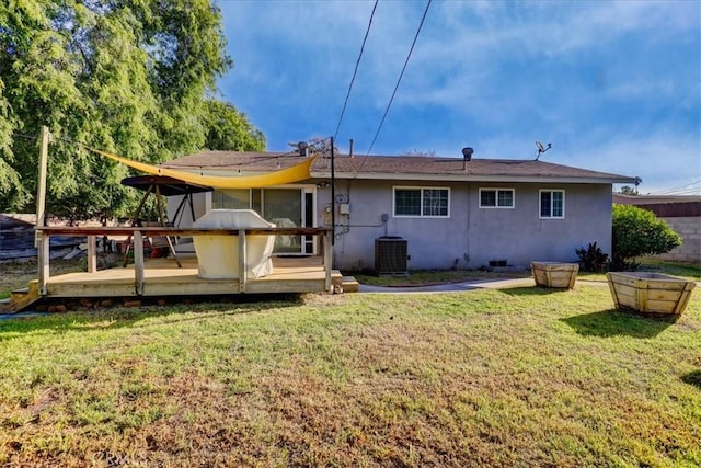 rear view of house with a wooden deck, central AC, stucco siding, and a lawn