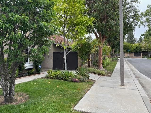 obstructed view of property with a front lawn and stucco siding