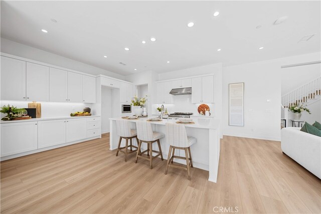 270 Maricopa, Irvine, CA 92618 - kitchen featuring under cabinet range hood, light wood-style floors, white cabinetry, light countertops, and recessed lighting