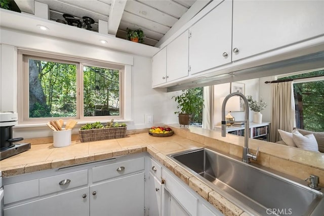 1359 Berwick Dr, Cambria, CA 93428 - kitchen with a sink, white cabinetry, light countertops, and beamed ceiling