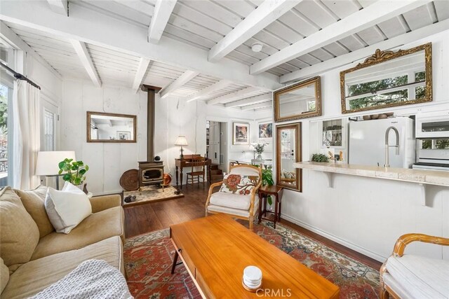 1359 Berwick Dr, Cambria, CA 93428 - living area featuring hardwood / wood-style flooring, a wood stove, and beamed ceiling