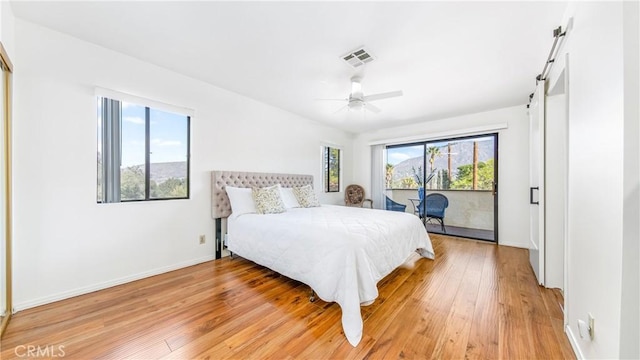 7948 Glenties Way, Sunland, CA 91040 - bedroom with light wood-type flooring, baseboards, a barn door, access to outside, and ceiling fan