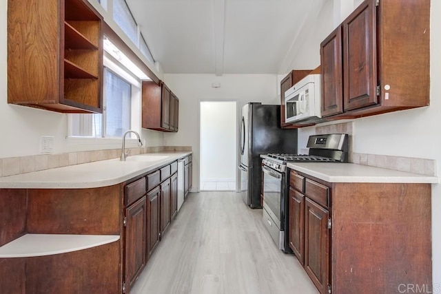 5019 Havenwood Ave, San Diego, CA 92120 - kitchen featuring stainless steel gas stove, white microwave, a sink, open shelves, and light wood-style flooring