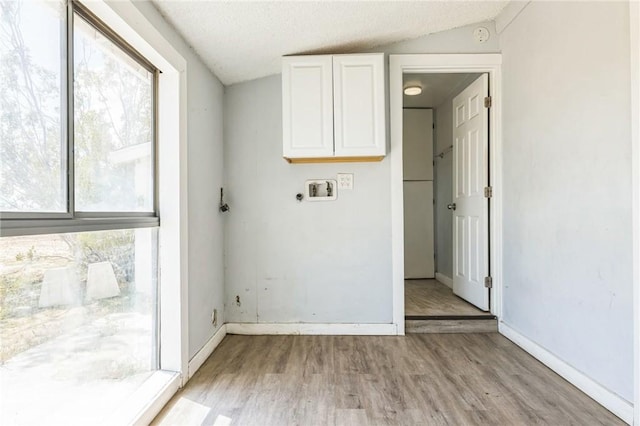 1561 Old Woman Springs Rd, Yucca Valley, CA 92284 - laundry area featuring washer hookup, light wood finished floors, cabinet space, baseboards, and a textured ceiling