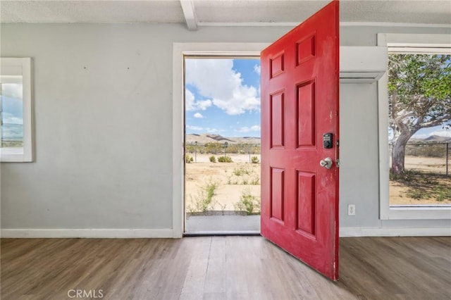 1561 Old Woman Springs Rd, Yucca Valley, CA 92284 - entryway with wood finished floors, baseboards, and a wall mounted air conditioner