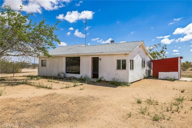 1561 Old Woman Springs Rd, Yucca Valley, CA 92284 - view of front of property with fence, stucco siding, a shingled roof, and dirt driveway