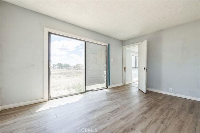 1561 Old Woman Springs Rd, Yucca Valley, CA 92284 - spare room with wood finished floors, a textured ceiling, and baseboards