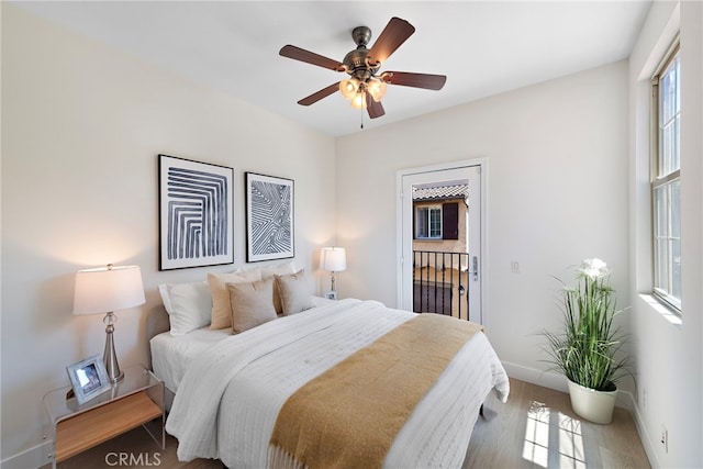 bedroom featuring baseboards, wood finished floors, and a ceiling fan