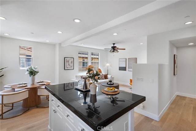 kitchen with tile counters, plenty of natural light, white cabinetry, light wood-type flooring, and recessed lighting