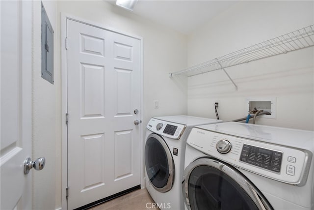 clothes washing area with washing machine and clothes dryer and electric panel