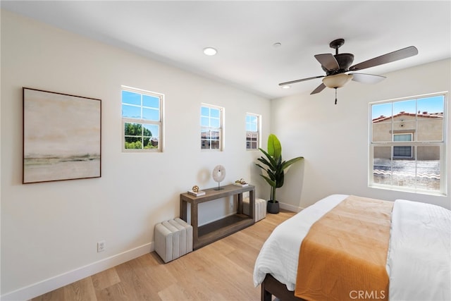 bedroom featuring multiple windows, baseboards, light wood-style flooring, and recessed lighting
