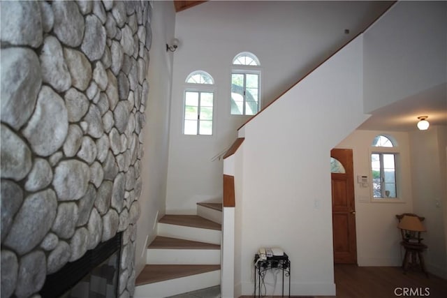 319 Dorn Dr, Crestline, CA 92325 - stairs with healthy amount of natural light, wood finished floors, a stone fireplace, and baseboards