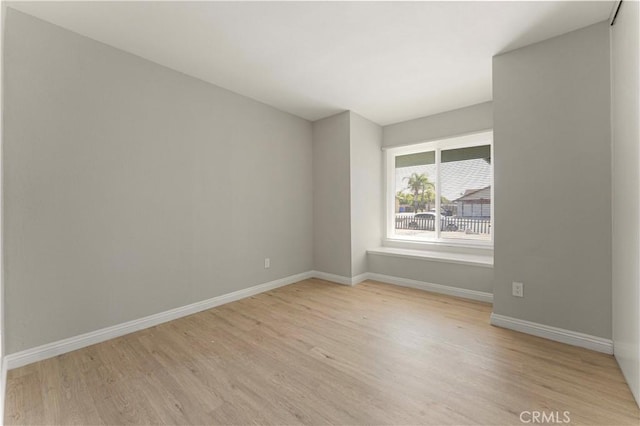 spare room featuring light wood-style floors and baseboards