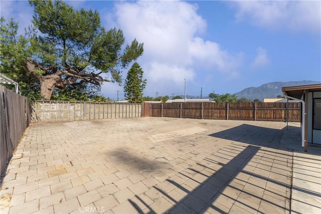 view of patio / terrace with a fenced backyard and a mountain view