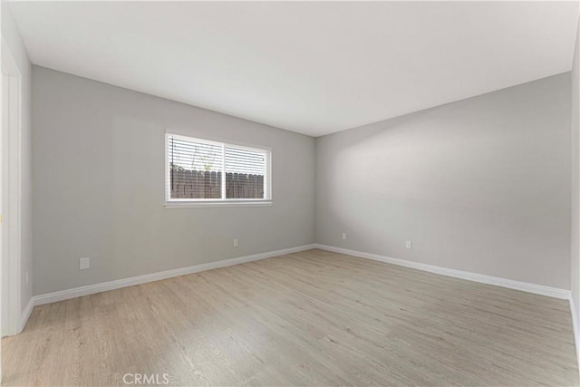 unfurnished room featuring light wood-style flooring and baseboards