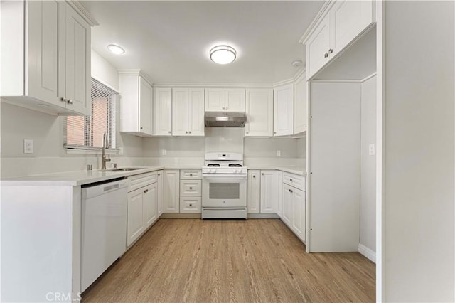 kitchen featuring white appliances, a sink, under cabinet range hood, light wood-style floors, and white cabinetry