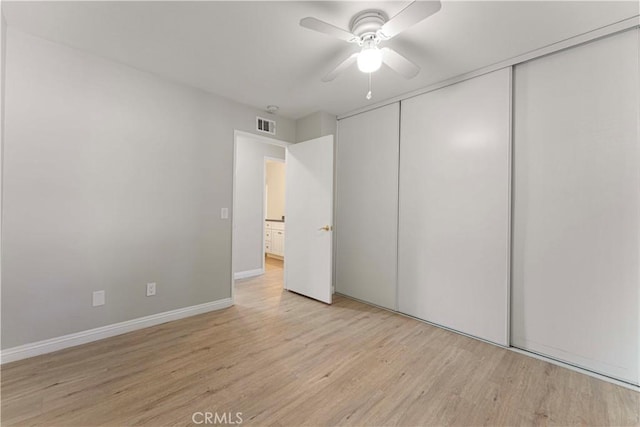 unfurnished bedroom with light wood-style flooring, a closet, ceiling fan, and baseboards