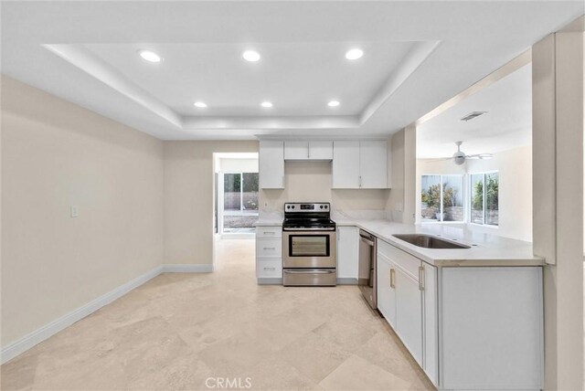 25101 Sebastian Ln, Mission Viejo, CA 92691 - kitchen with stainless steel appliances, a tray ceiling, light countertops, white cabinets, and recessed lighting