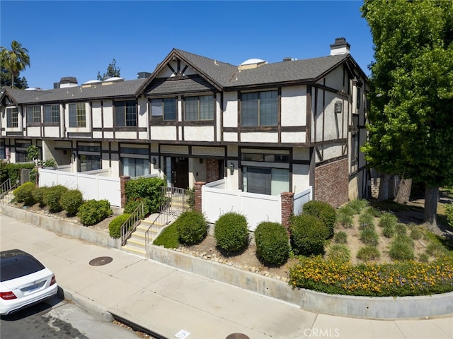 20737 Roscoe Blvd Unit 102, Winnetka, CA 91306 - view of front facade with stucco siding, brick siding, and a chimney
