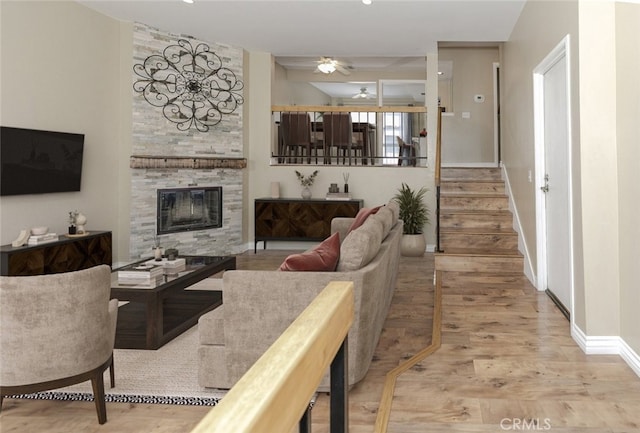 20737 Roscoe Blvd Unit 102, Winnetka, CA 91306 - living area featuring wood finished floors, a ceiling fan, a large fireplace, and stairway