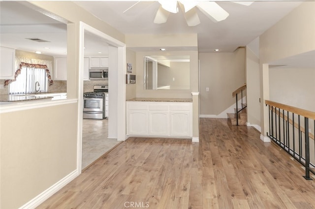 20737 Roscoe Blvd Unit 102, Winnetka, CA 91306 - corridor featuring light wood-type flooring, a sink, baseboards, stairway, and recessed lighting