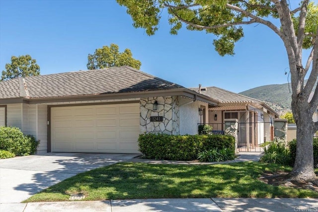 view of front of home featuring an attached garage, concrete driveway, and a mountain view