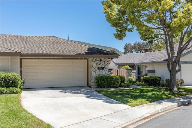 single story home featuring driveway, a garage, stone siding, a front yard, and stucco siding