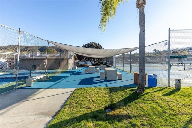 view of home's community with a tennis court