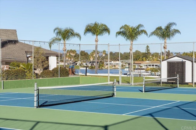 view of tennis court with community basketball court and fence