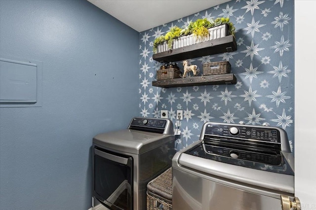 laundry area with washing machine and clothes dryer and wallpapered walls