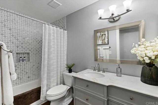 full bath featuring tiled shower, vanity, toilet, and a chandelier