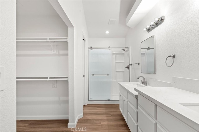6175 Showdown Cir, Magalia, CA 95954 - bathroom featuring a shower stall, wood finished floors, double vanity, a spacious closet, and recessed lighting