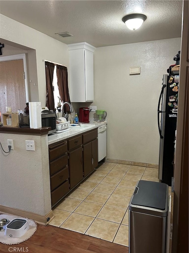 3641 Oak Creek Dr Unit G, Ontario, CA 91761 - kitchen with a sink, white dishwasher, light countertops, a textured ceiling, and white cabinetry