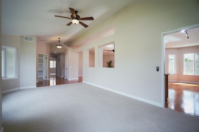 unfurnished living room featuring carpet, a ceiling fan, and baseboards